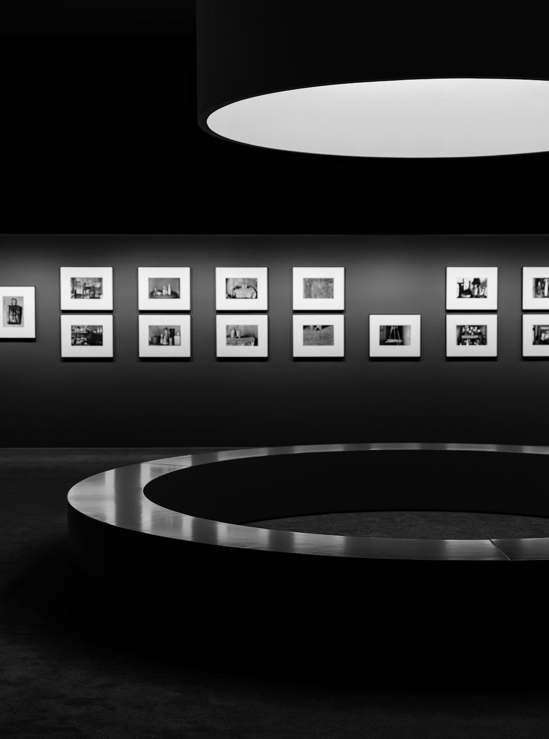 Fotografías en blanco y negro enmarcadas en una pared de galería.