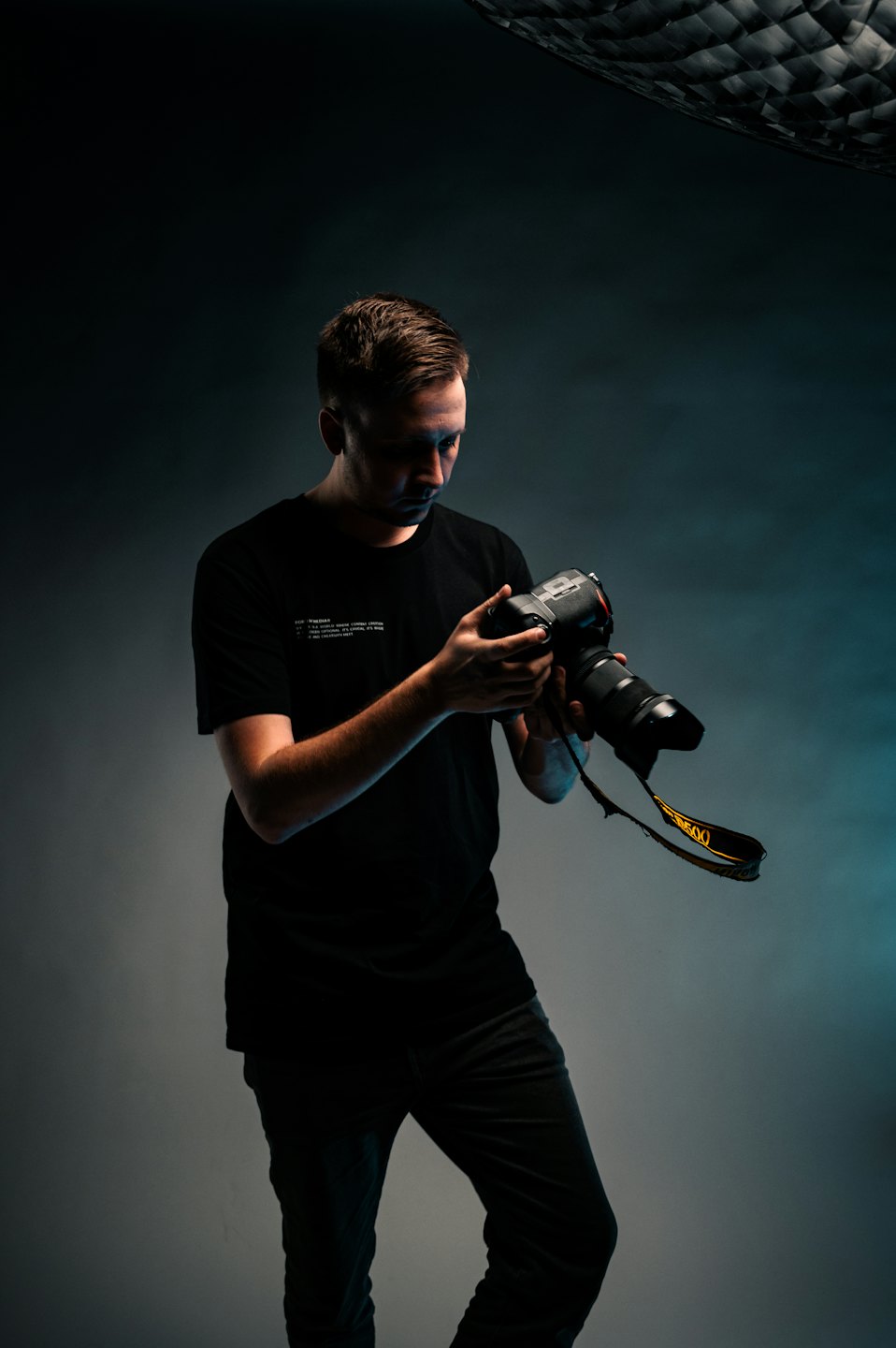 Fotógrafo ajusta cámara con teleobjetivo en estudio.